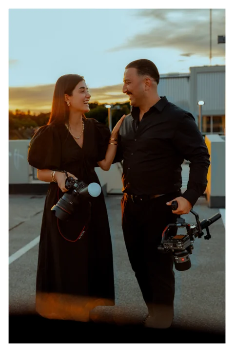 Sevtu und Tarik lachen gemeinsam mit ihren Kameras